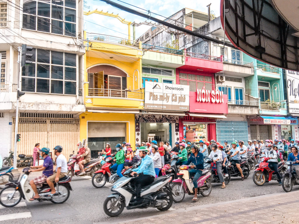 More than a dozen scooters driving in a street in Vietnam