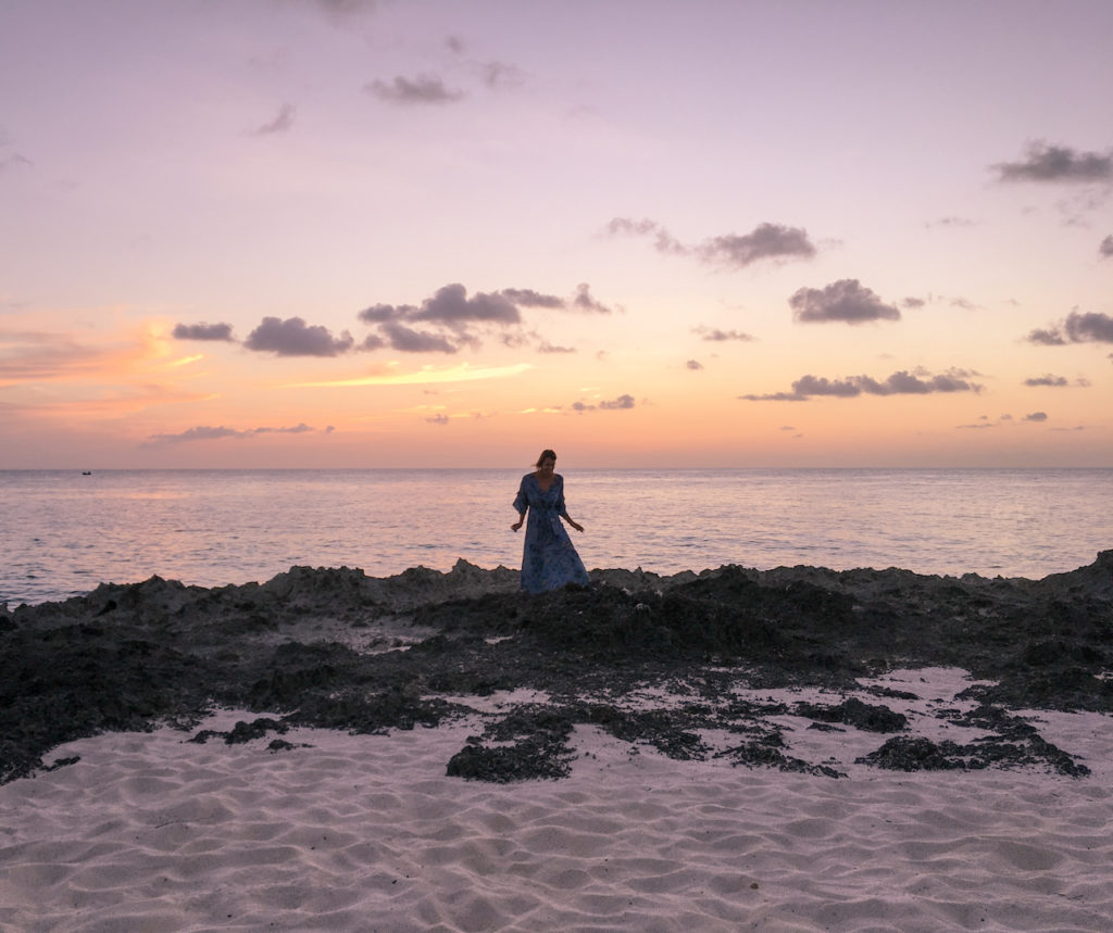 A woman in a blue dress during sunset on the beach in San Andres Colombia