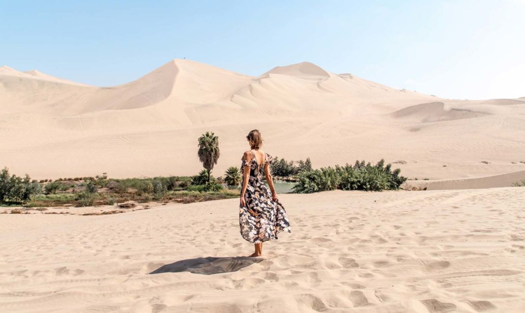 woman in a dress in Huacachina desert with oasis