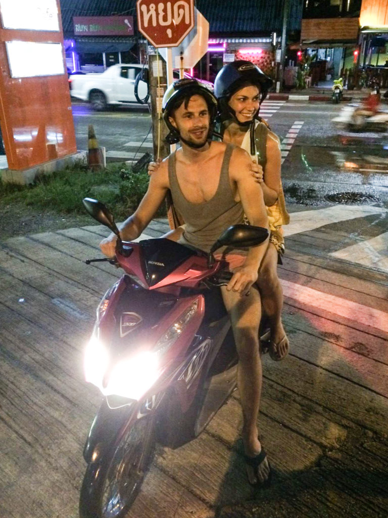 two people sitting on scooter at nighttime