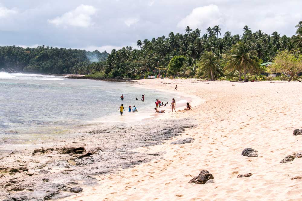 a beach on Siargao with kids playing in the background