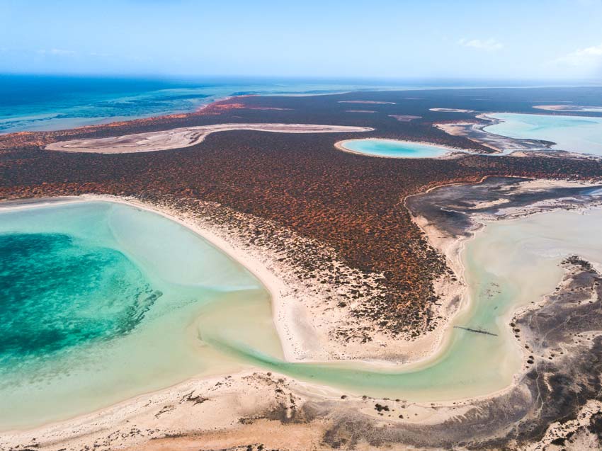 view on turquoise water and red sand beach in Francois Peron National Park