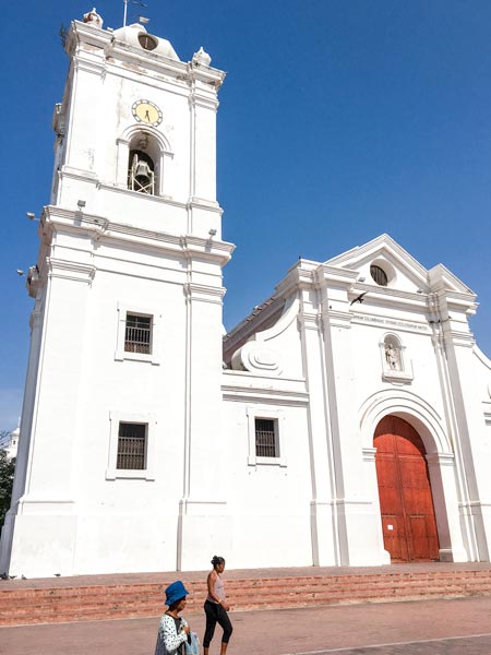 a view on the white church and two people walking 