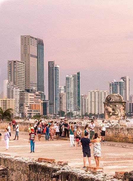 people looking at the skyscrapers and on the pink sky in Cartagena