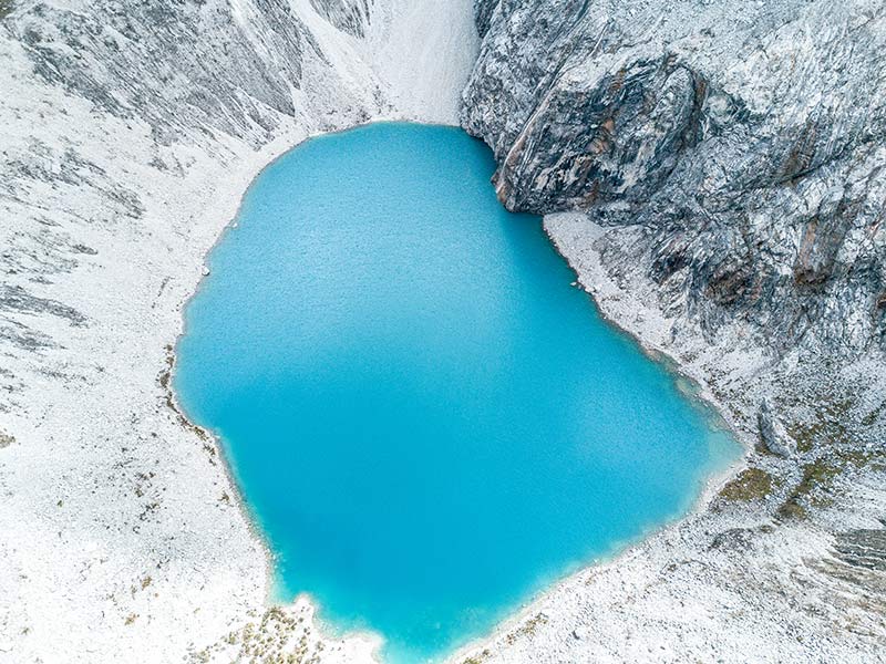 blue lake with white mountains in laguna 69 in Peru, close to Huaraz