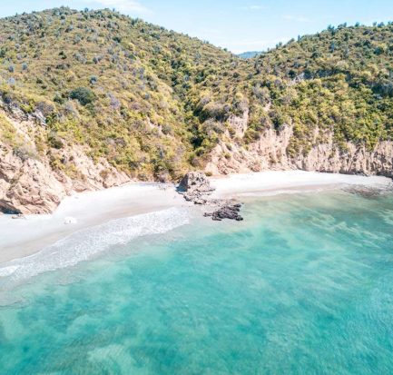 white cliff, green hills and blue emerald waters on Los Frailes in Ecuador