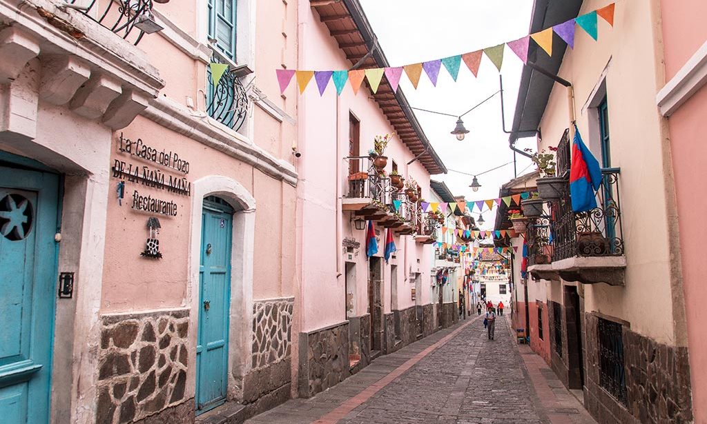colourful La Ronda street with pink walls, turquoise door in Quito, Ecuador