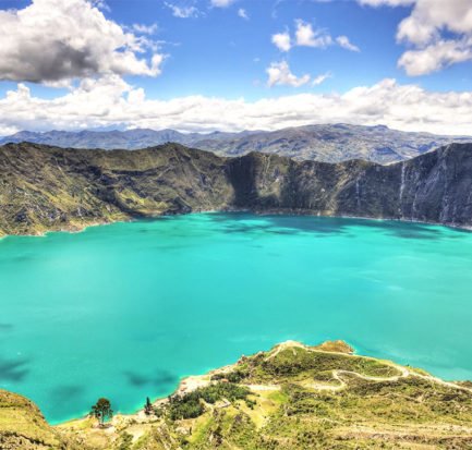 lake with turquoise water, mountains in the background and green grass in Quilotoa lake, Ecuador