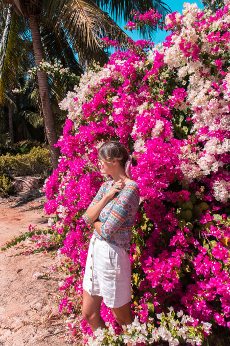 a woman standing in front of purple flower wall in Broome, Western Australia
